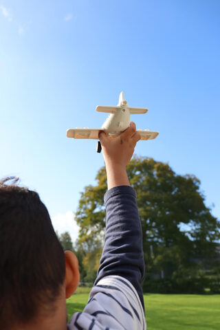 Enfant jouant avec un avion en bois